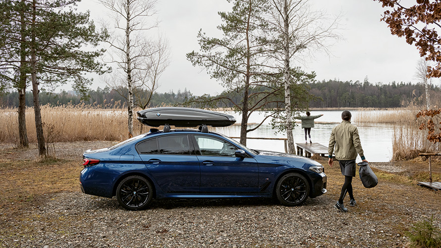 BMW med tagboks parket foran en sø.